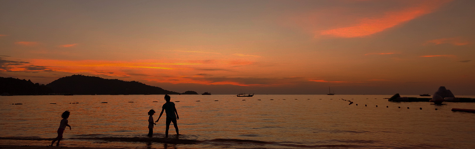 Phuket, Thailand - March 16, 2011 : Mother and children enjoying the beuatiful sunset at Patong Beach in Phuket